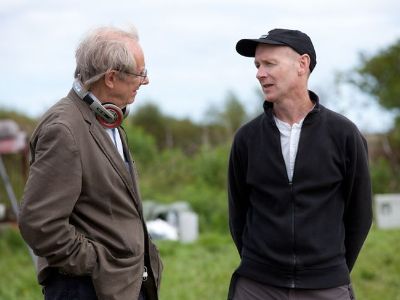 Paul Laverty and Ken Loach are talking to each other in the fields in the picture.